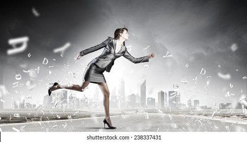 Young Pretty Businesswoman In Suit Running Away