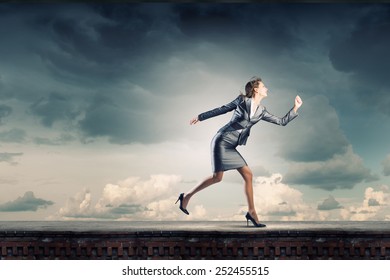 Young Pretty Businesswoman In Suit Running Away