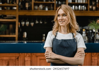 Young pretty caucasian waitress small business owner barista bartender standing in blue apron looking at the camera with arms crossed at the bar counter in restaurant. - Powered by Shutterstock