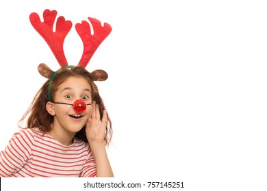 Young Pretty Curly Haired Girl Wearing Red Nose And Reindeer Antlers Listening To Something With Her Hand To Her Ear Isolated Copyspace Overhearing Christmas X-mas Merry New Year Kids Children