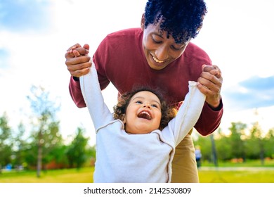 Young Pretty Dad And His Little Curly Daughter Walk Together Outdoors At Sunset Light