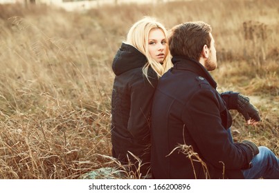 Young Pretty Fashion Sensual Couple In Love Sitting In Winter Cold Field