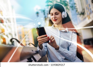 Young pretty female freelancer working outdoors using her laptop and mobile phone sitting on the street bench. Social network and mobile applications infographics.  Education and freelance concept. 