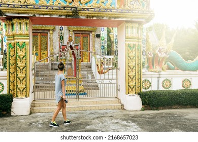 Young pretty female tourist is sightseeing an ancient buddhist temple in Thailand.