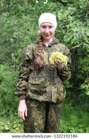 Young and pretty girl in the forest collects linden flowers for brewing tinctures for colds. The girl collects herbal tea.