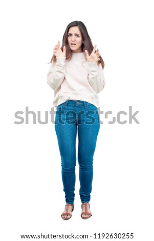 young pretty girl full body shouting with a crazy, amazed look of surprise, with both hands in the air.