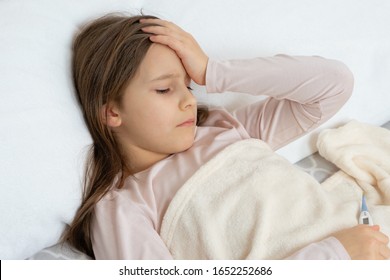 Young Pretty Girl Lies Sick In Bed, Feeling Sick, Fever And Headache At High Temperature In A Child, Studio