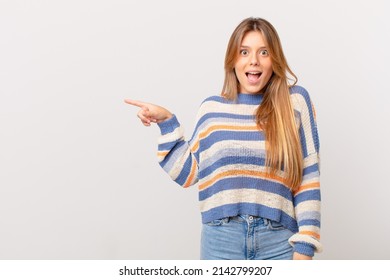 young pretty girl looking happy and pleasantly surprised - Shutterstock ID 2142799207