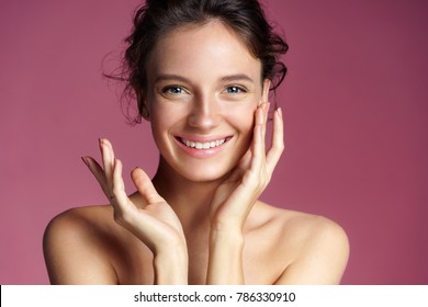 Young pretty girl with natural makeup on pink background. Beauty & Skin care concept