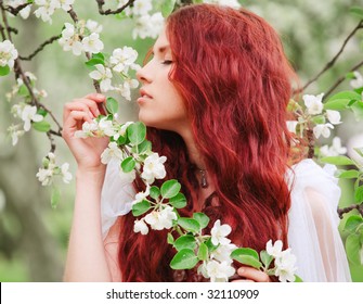 Young pretty girl with red hair in the garden