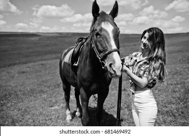 Young pretty girl stay with horse on a field at sunny day. - Shutterstock ID 681469492