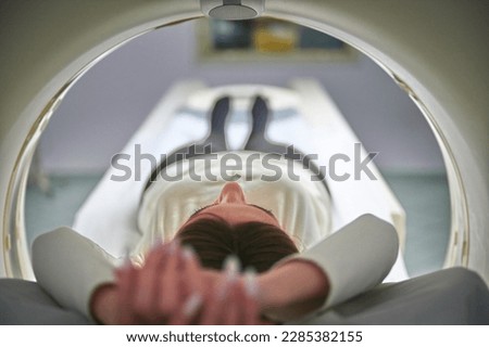 A young pretty girl is undergoing a CT scan in a medical clinic. Computed tomography scanning of the body. Prevention illness. Early detection of cancer.