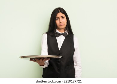 Young Pretty Hispanic Woman Feeling Sad And Whiney With An Unhappy Look And Crying. Waiter With Tray Concept