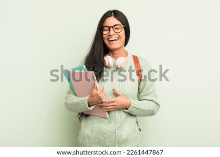 young pretty hispanic woman laughing out loud at some hilarious joke. student concept