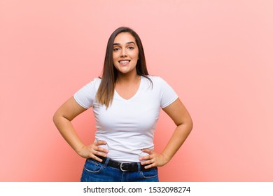 Young Pretty Hispanic Woman Looking Happy And Goofy With A Broad, Fun, Loony Smile And Eyes Wide Open Against Pink Wall