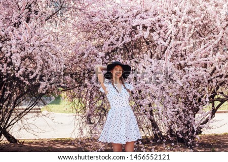 Young pretty lady with sakura flowers, blooming cherry