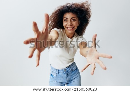 Young Pretty laughing cheerful friendly Latin woman 20s afro long hair in casual white shirt stretch hands isolated on over white color background studio portrait. Wide Angle View, Copy Space