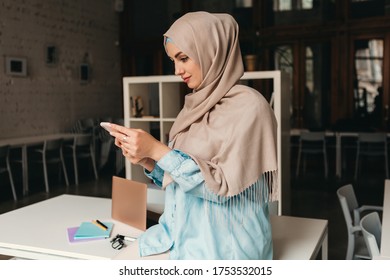 Young Pretty Modern Muslim Woman In Hijab Working In Office Room, Education Online, Remote Work Freelancer, Using Smartphone