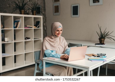 Young Pretty Modern Muslim Woman In Hijab Working On Laptop In Office Room, Education Online, Remote Work Freelancer, Typing Thinking Concentrated