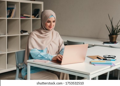 Young Pretty Modern Muslim Woman In Hijab Working On Laptop In Office Room, Education Online, Remote Work Freelancer, Typing Thinking Concentrated