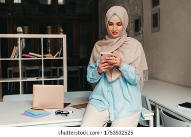 Young Pretty Modern Muslim Woman In Hijab Working In Office Room, Education Online, Remote Work Freelancer, Using Smartphone