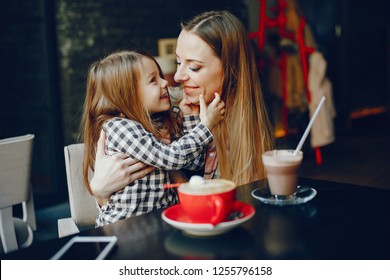 young and pretty mother sitting at the cafe with her little daughter  - Powered by Shutterstock