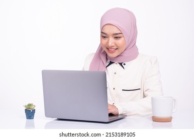 Young pretty muslim woman in hijab working on laptop. Copy space. - Powered by Shutterstock