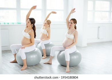 young pretty pregnant woman in sportive outfit stretching body in studio - Powered by Shutterstock