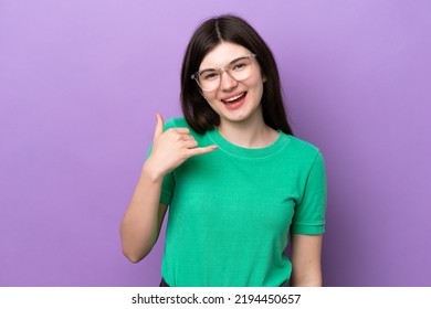 Young Pretty Russian Woman Isolated On Purple Background With Glasses And Doing Phone Gesture