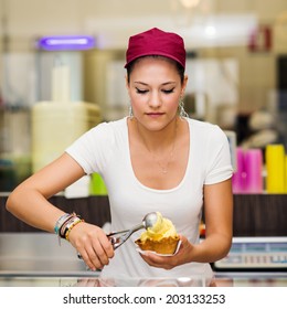 Young Pretty Saleswoman Portrait Inside Ice Cream Shop.