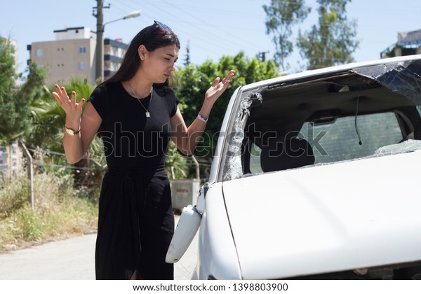 Young pretty scared woman in the car.\
Injured woman feeling bad after having a car\
crash