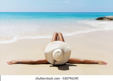 Young Pretty Slim Brunette Woman In Hat And Sunglasses Sunbathe On The Tropical Beach In Bikini