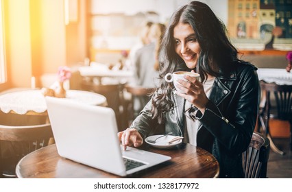 Young Pretty Spanish Woman In Cafe In City Centre With Tablet Laptop