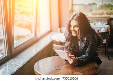 Young pretty spanish woman in cafe in city centre with tablet laptop