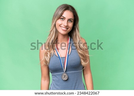 Young pretty sport Uruguayan woman with medals over isolated background laughing