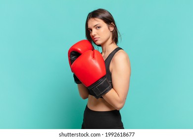 young pretty sport woman angry expression and a boxing gloves