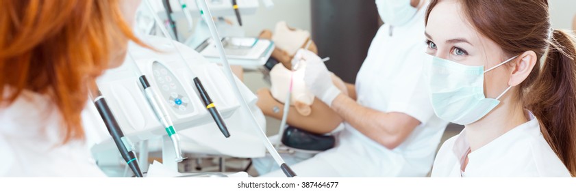 Young Pretty Student Of Stomatology Curse With Protective Mask During Classes With Professor