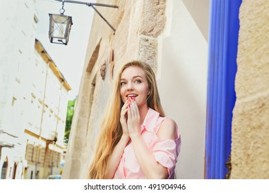 Young Pretty Surprised Girl With Extra Long Blonde Hair In Light Pink Dress On The City Streets. Beautiful Shocked Or Surprised Woman Outdoors. 