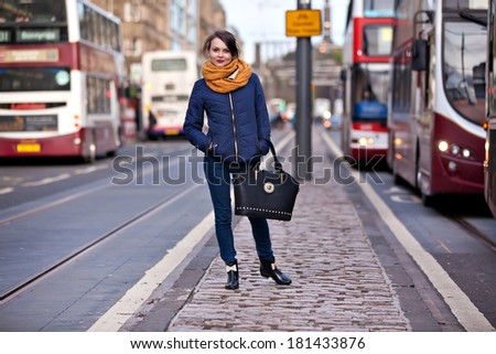 Young pretty teenage girl walking in the middle of Princess street in Edinburgh city