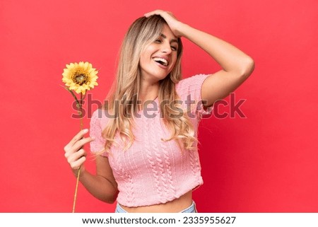 Young pretty Uruguayan woman holding sunflower isolated on background has realized something and intending the solution