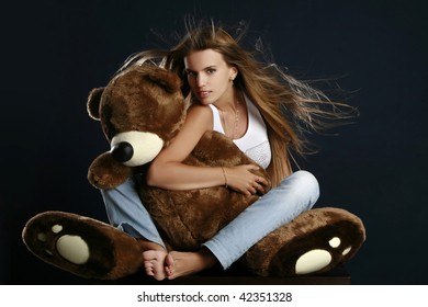 Young Pretty Woman With Big Teddy Bear Posing In Studio.