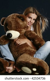 Young Pretty Woman With Big Teddy Bear Posing In Studio.