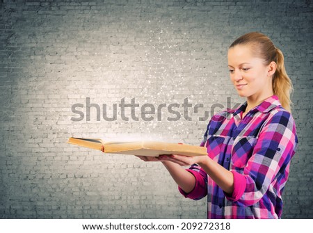 Young pretty woman in casual holding opened book