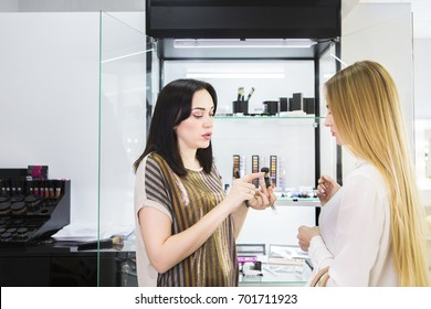 Young Pretty Woman Chosing Color Cosmetic And Beauty Consultant In Shop Or Beauty Salon