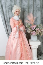 Young pretty woman closeup in pink royal dress. Marie Antoinette cosplay