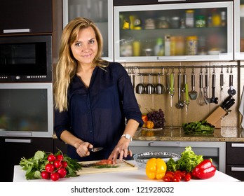 Young Pretty Young Woman Cooking Fish In Kitchen