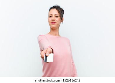 young pretty woman with a credit card against white wall - Shutterstock ID 1526136242