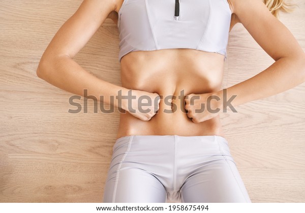 Young pretty woman do breathing exercise. Home\
sport workout. Healthy lifestyle. Long blond hair. Female person\
body. Vacuum yoga belly gymnastics. Lock abdominal. Nauli active\
positioin. Abs muscle