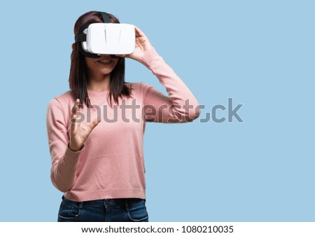 Young pretty woman excited and entertained, playing with virtual reality glasses, exploring a fantasy world, trying to touch something