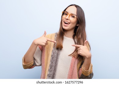 Young Pretty Woman Feeling Happy, Surprised And Proud, Pointing To Self With An Excited, Amazed Look Against Blue Wall